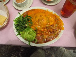 stuffed sopapilla covered in cheese and green chile